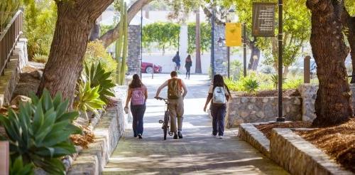 Pitzer College students walking along shady pathway